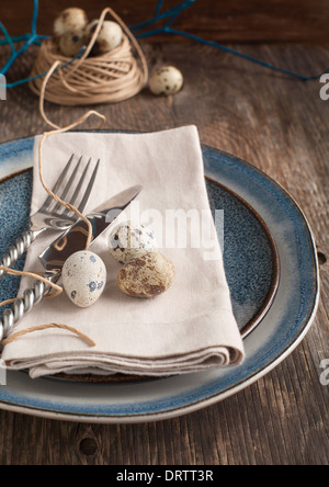 Pasqua messa in tavola con uova di quaglia vecchio tavolo in legno Foto Stock