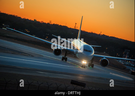 Linea aerea passeggeri in rullaggio a getto nel brillante bagliore del tramonto a Atlanta International Airport di Atlanta, Georgia. (USA) Foto Stock