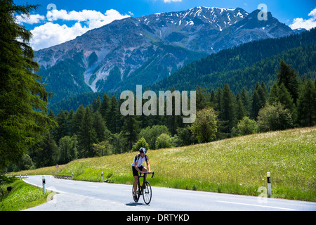 Escursioni in bicicletta in salita nel Parco Nazionale Svizzero con lo sfondo delle alpi svizzere, Svizzera Foto Stock