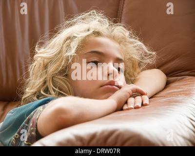 Bambina guarda la televisione. La ragazza è la menzogna e la messa a fuoco. Foto Stock