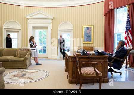 Il Presidente Usa Barack Obama parla al telefono con AFL-CIO Presidente Richard Trumka durante una chiamata nell'Ufficio Ovale della Casa Bianca Agosto 21, 2013 a Washington, DC. Ascolto da sinistra sono: Rob Nabors, Vice Capo di Gabinetto per politica; Alyssa Mastromonaco, Vice Capo del personale per le operazioni e capo del personale Denis McDonough. Foto Stock