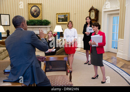 Il Presidente Usa Barack Obama si prepara per un incontro con il columnist economico nell'Ufficio Ovale della Casa Bianca Agosto 20, 2013 a Washington, DC. Da sinistra sono: Kathryn Ruemmler, Consigliere del Presidente; Communications Director Jennifer Palmieri; Katie Beirne Fallon, Vice Direttore delle comunicazioni; e Cecilia Muñoz, direttore della politica interna del Consiglio. Foto Stock