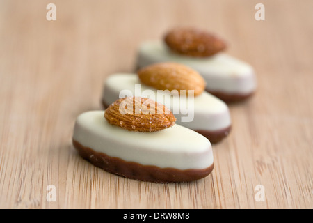 Tre cioccolati di lusso su una scheda di bambù. Foto Stock