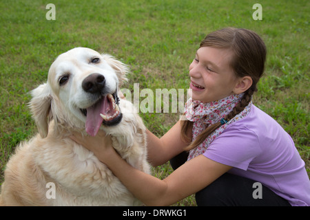 Bambini che giocano con un cane su un verde prato Foto Stock