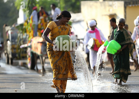 Cerimonia indiana dedicato alla dea Devi - trasporto della statua della dea Devi con donne versando acqua per le benedizioni del Sud dell India Foto Stock