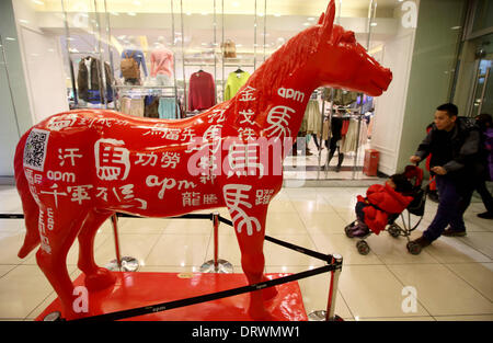 (140203) -- PECHINO, Febbraio 3, 2014 (Xinhua) -- i clienti a piedi passato un cavallo scultura in un centro commerciale per lo shopping sulla Wangfujing Street, una zona commerciale di Pechino, capitale della Cina, Febbraio 2, 2014. Il nuovo anno lunare, o Festival di Primavera, inizia a gennaio 31 e segna l inizio dell anno del cavallo, secondo lo zodiaco cinese. (Xinhua)(wjq) Foto Stock