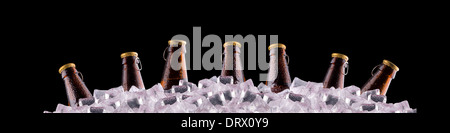 Bottiglie di birra sul ghiaccio su sfondo nero Foto Stock