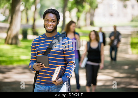 Felice studente Azienda digitale compressa sul campus Foto Stock