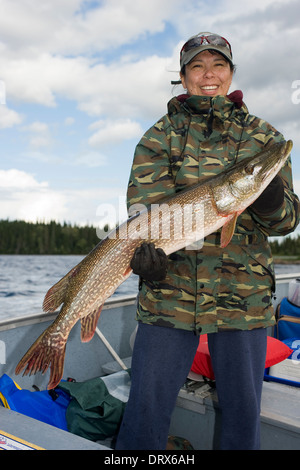 Donna pescatore tenendo in mano un grosso luccio del nord ha catturato da una barca sul lago nel nord Ontario, Canada Foto Stock