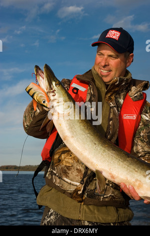 Il pescatore con in mano una enorme muschiato catturati in Ontario del nord. Foto Stock