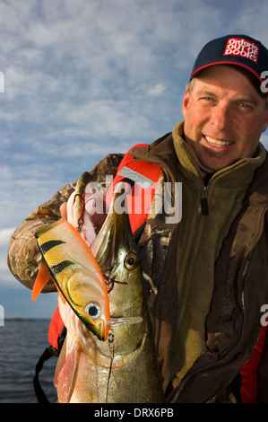 Il pescatore con in mano una enorme muschiato catturati in Ontario del nord. Foto Stock