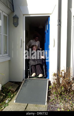 Regno Unito west sussex una donna anziana scendendo una rampa per sedia a rotelle Foto Stock