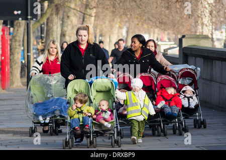 Giovani madri a piedi lungo il Tamigi bank su una mattina dei giorni feriali, Londra England Regno Unito Regno Unito Foto Stock