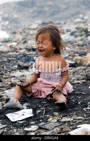 Una giovane ragazza che vivono in condizioni di povertà che grida di dolore al tossico e inquinato Stung Meanchey discarica in Phnom Penh Cambogia. Foto Stock