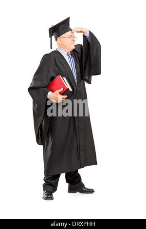 A piena lunghezza Ritratto di un maschio di professore universitario in abito di graduazione cercando con la mano sopra gli occhi Foto Stock