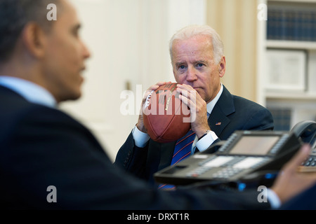 Il Presidente Usa Barack Obama con il Vice Presidente Joe Biden, conduce a una chiamata in conferenza con Rob Nabors, vice capo di Stato Maggiore per la politica e il leader della maggioranza del Senato Harry Reid per discutere il governo federale lo spegnimento e il soffitto del debito nell'Ovale Officeof alla Casa Bianca di Ottobre 15, 2013 a Washington, DC. Foto Stock