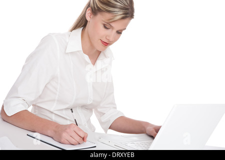 Donna che lavorano con il computer portatile e scrivere note Foto Stock