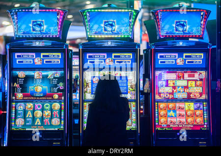 London, Regno Unito - 4 February 2014: una donna che gioca a slot machines all'ICE totalmente Gaming 2014 mostrano, il più grande evento nel settore dei giochi. Credito: Piero Cruciatti/Alamy Live News Foto Stock