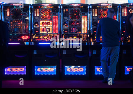 London, Regno Unito - 4 February 2014: un uomo gioca a slot machines all'ICE totalmente Gaming 2014 mostrano, il più grande evento nel settore dei giochi. Credito: Piero Cruciatti/Alamy Live News Foto Stock
