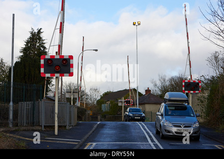 Vetture su strada di attraversamento di piccole dimensioni a livello locale attraversando dunmurry Belfast Regno Unito Foto Stock