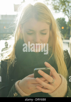 Giovane donna utilizza lo smartphone Foto Stock