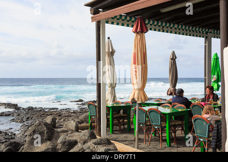 La gente di pranzare in un ristorante sulla spiaggia con una vista che domina il mare in El Golfo, Lanzarote, Isole Canarie, Spagna Foto Stock