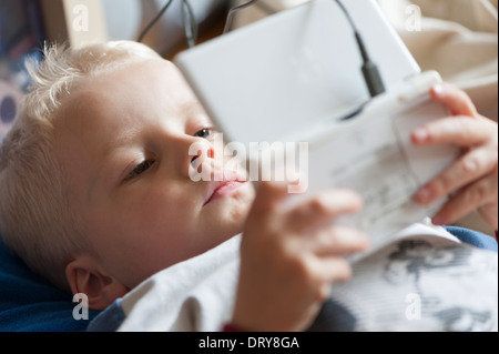 5 anni di vecchio ragazzo giocando con il suo Nintendo DS CONSOLE DI GIOCO Foto Stock