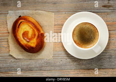 Tazza di caffè espresso e bun su sfondo di legno Foto Stock