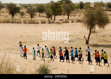 BURKINA FASO Dori, crescente terrore islamista in questa regione, questa regione è dichiarata zona rossa in relazione agli attacchi terroristici e all'insicurezza, scuola cattolica, bambini marciano di fila con la croce in savana secca Foto Stock