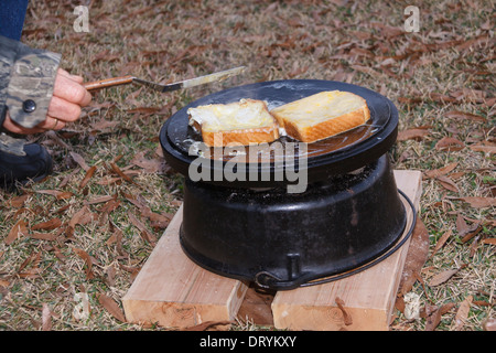 Forno olandese cucina outdoor ghisa o nero ferro  pentola con coperchio e  supporto metallico disco Foto stock - Alamy