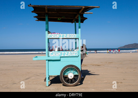 Un carrello di legno dipinto luminosamente utilizzato per la vendita di Granizado copos o sulla spiaggia di Playa Tamarindo, Guanacaste in Costa Rica Foto Stock