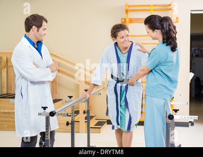 Paziente femmina di essere assistita da fisioterapisti Foto Stock