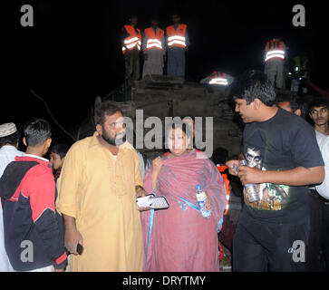 Karachi. 4 febbraio, 2014. Una donna reagisce al sito di attacco nei pressi del sud porta pakistano città di Karachi, Febbraio 4, 2014. Almeno quattro persone sono state uccise e 14 altri tra cui due bambini e otto donne feriti quando sette vani di un treno deragliato a seguito di una bomba su un binario ferroviario in Pakistan meridionale della città portuale di Karachi il Martedì notte i media locali hanno riferito. Credito: Masroor/Xinhua/Alamy Live News Foto Stock