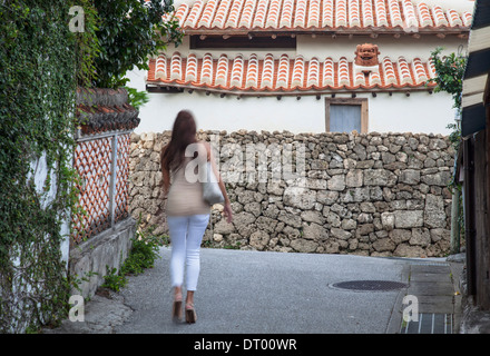 Donna che cammina lungo la strada di Tsuboya pottery village, Naha, Okinawa, in Giappone Foto Stock