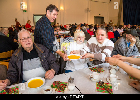Persone senza dimora sono una cena di Natale, servito da volontari di una comunità della Chiesa locale. Foto Stock