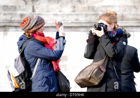 Londra, Inghilterra, Regno Unito. Due giovani donne di scattare le foto in Trafalgar Square Foto Stock