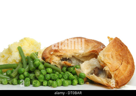 Primo piano di un pollo e torta a fungo con purea di patate, fagioli e piselli contro uno sfondo bianco Foto Stock