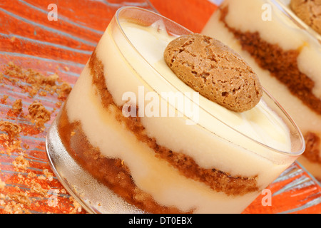 Close-up di crema alla vaniglia e amaretti dessert servito in bicchieri di vetro. Messa a fuoco selettiva. Foto Stock