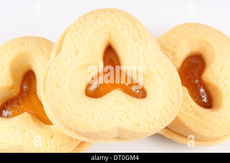 Close-up di alcuni di pasta frolla biscotti con marmellata di albicocche su uno sfondo bianco. Foto Stock