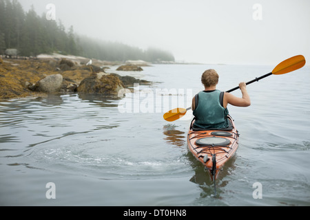 Lo stato di New York STATI UNITI D'AMERICA uomo canoa kayak su acqua calma misty condizioni Foto Stock
