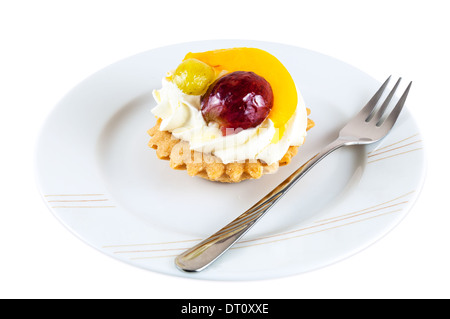 Tortina dolce con frutta e panna montata sulla piastra con forcella isolati su sfondo bianco Foto Stock