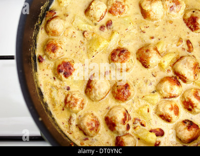 Primo piano della carne di tacchino a sfera e il curry ananas nella padella sul fornello Foto Stock