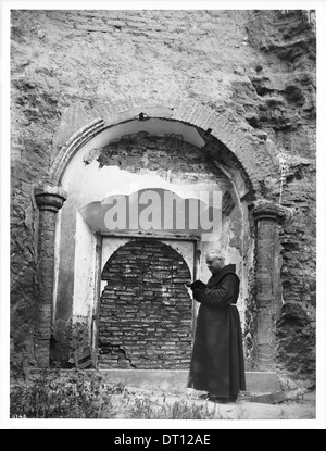 Padre Superiore O'Keefe sta in piedi in una parete fino a Porta della Missione di San Luis Rey de Francia, California, 1904 Foto Stock