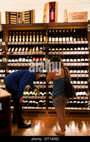 Il cliente nel reparto di vino a Dallmayr negozio di alimentari a Monaco di Baviera, Germania Foto Stock