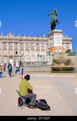 Madrid, Spagna. Plaza de Oriente. Statua di Felipe Filippo IV (Pietro Tacca; 1639) di fronte al Palazzo Reale. Il chitarrista musicista di strada Foto Stock