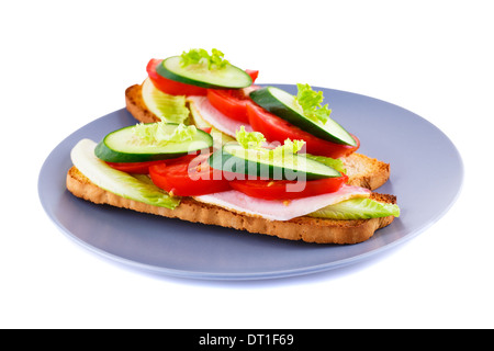 Fette biscottate panini con lattuga, pomodoro, cetriolo e carne di maiale lion su piastra isolata su sfondo bianco. Foto Stock