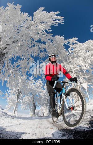 Krasny Les, Repubblica Ceca. 26 gen 2014. Racing ciclista Tino Zieger cicli attraverso il bianco paesaggio invernale dei Monti Metalliferi vicino a Krasny Les, Repubblica ceca, 26 gennaio 2014. (Modello rilasciato) Foto: Arno Burgi/dpa/Alamy Live News Foto Stock