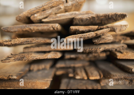 Un cumulo di materiale riciclato rigenerato listoni di legno di legno ecologicamente responsabile bonifica in un deposito di legname Foto Stock