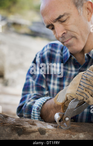 Un legname rigenerati workshop un uomo preparare il legname rimuovendo tutti i chiodi e viti prigioniere Foto Stock