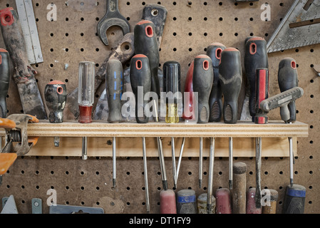 Un legname rigenerati workshop un utensile bordo con slot per cacciaviti e palmare gli strumenti per la lavorazione del legno Foto Stock